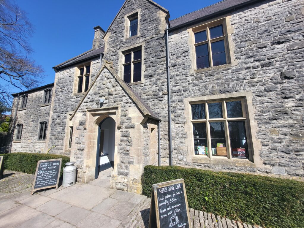 Main entrance to Somerset Rural Life Museum, showing stone farm buildings and rural setting in Glastonbury