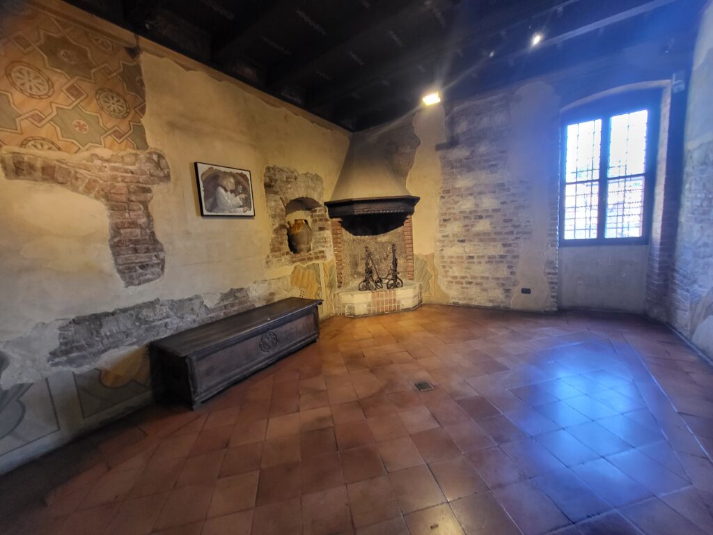 Room with painted walls and stone fireplace in Juliet’s House museum