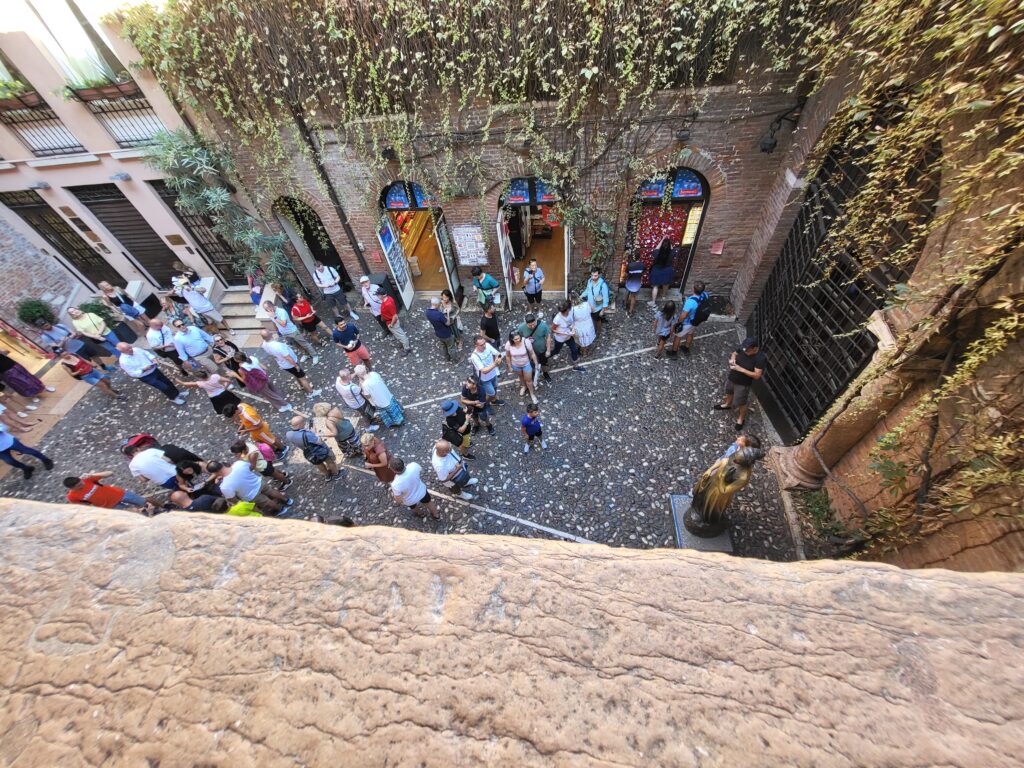 View from Juliet’s balcony showing tourists and bronze statue below