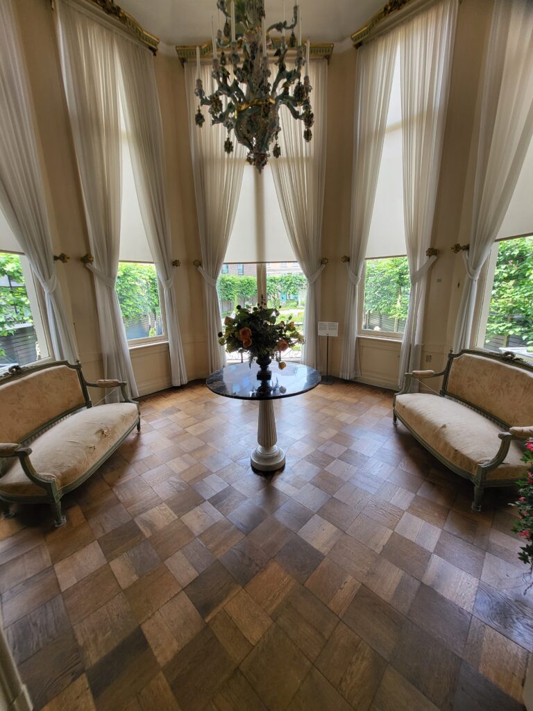Elegant salon interior with chandelier, table and armchairs