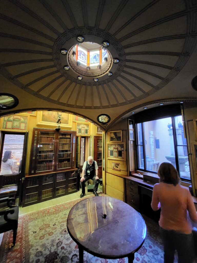 Small historic room with a domed ceiling, bookcases and a table at Sir John Soane's Museum in London